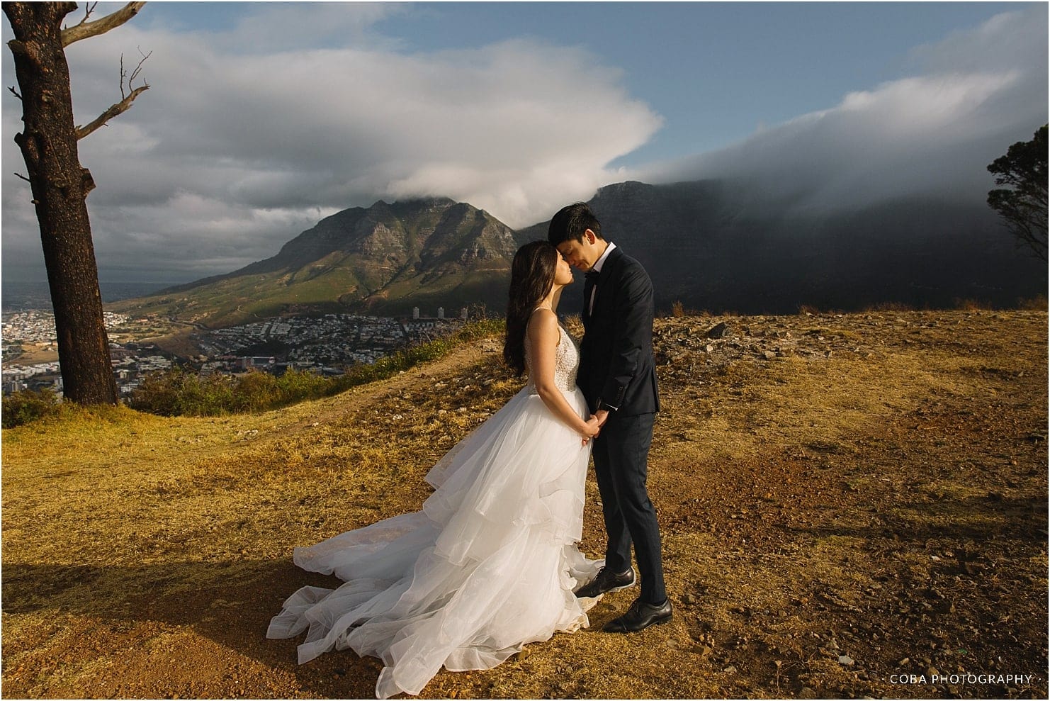 couple in wedding attire with table mountain