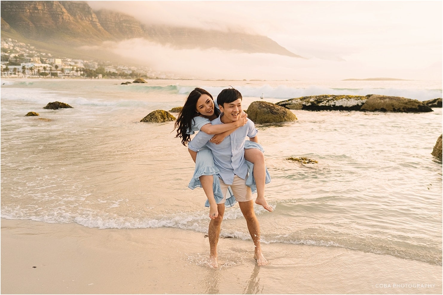 couple having fun with piggy back ride campsbay beach