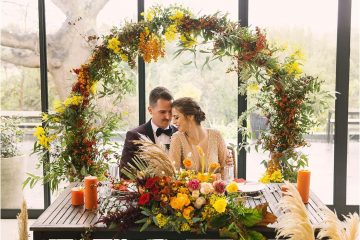 wedding couple at table of colourful decor at the conservatory