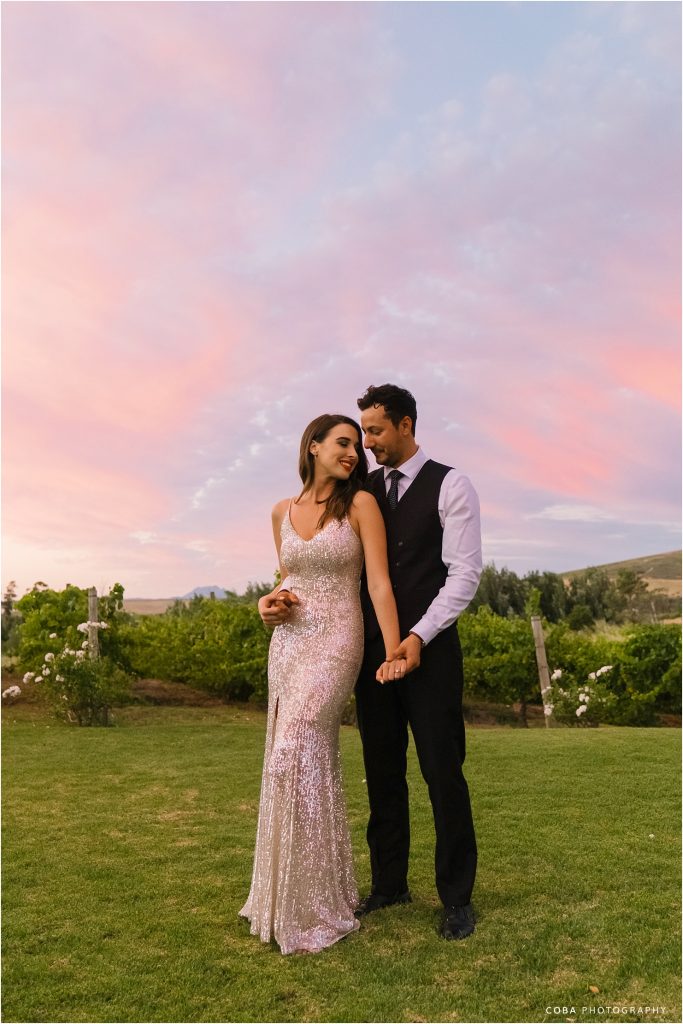neo venue wedding- bride and groom with pink sunset sky