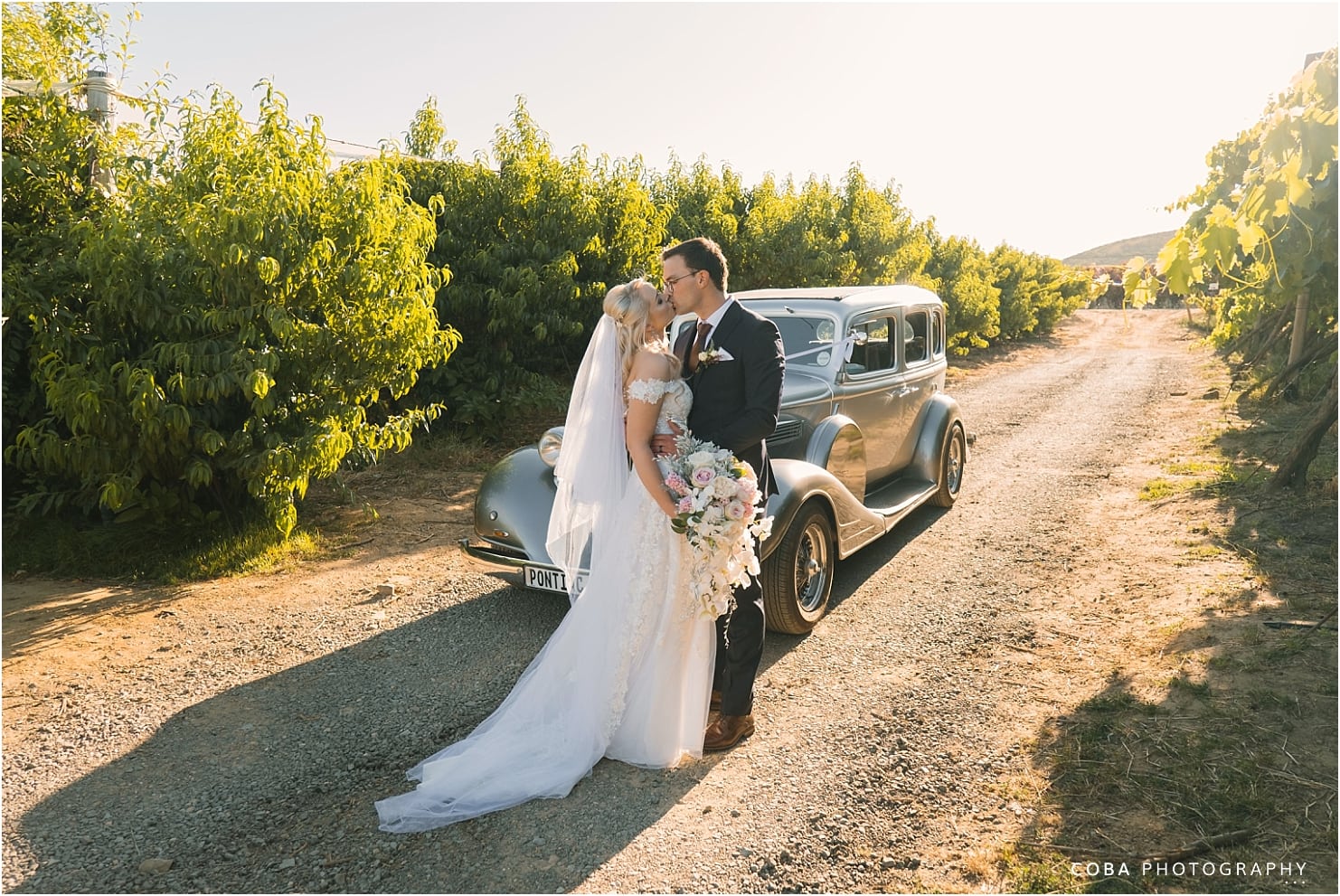 Het Vlock Casteel Wedding - couple kissing in front of vintage wedding car