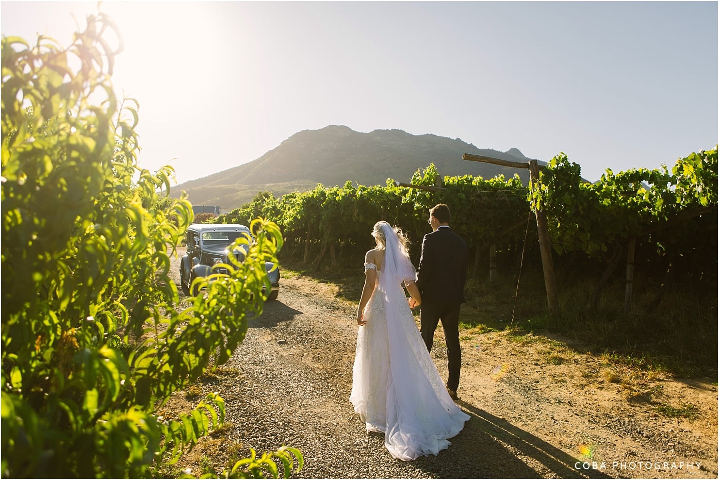 Het Vlock Casteel Wedding - couple walking into the sunset with view of the mountains and vineyards