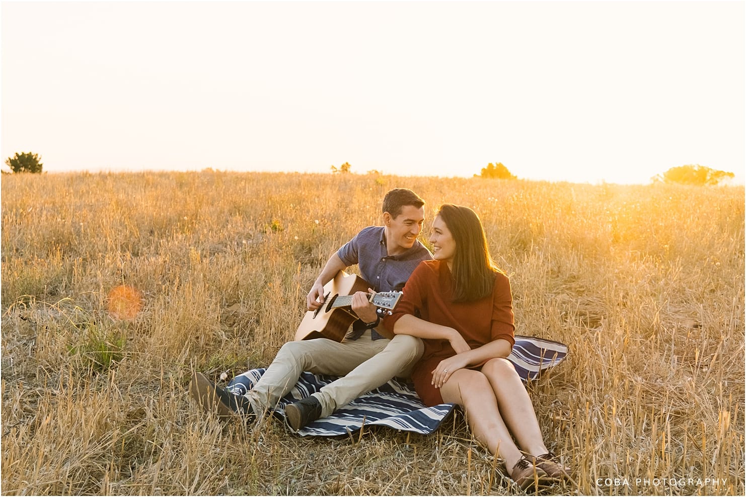 sunset couple shoot in stellenbosch - guy plays guitar to his fiance