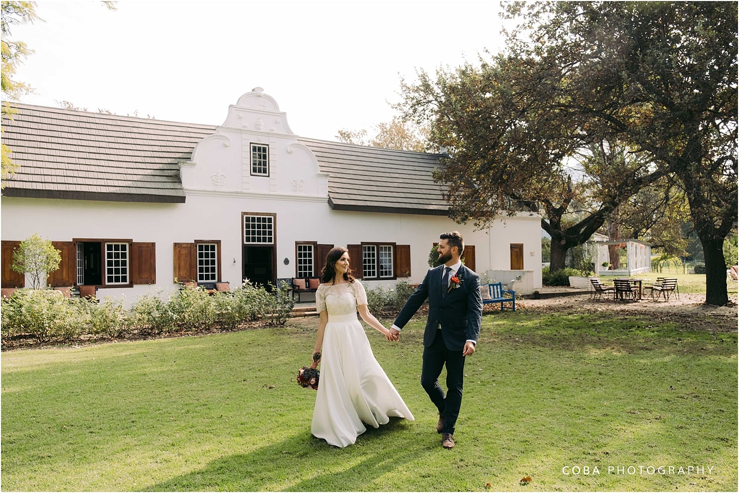 montpellier wedding tulbagh - bride and groom walking in front of manor house
