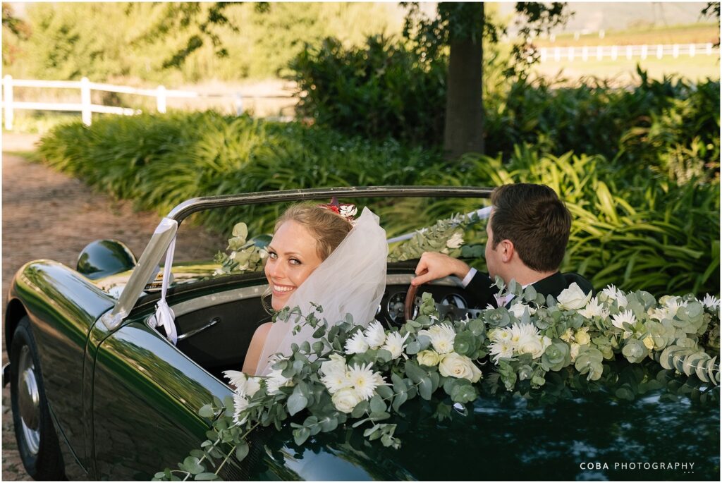 wedding at zorgvliet - couple driving away in green vintage car