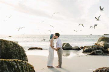 Engagement beach photo of Yutaro and Rei walking along Camps Bay shoreline at sunset