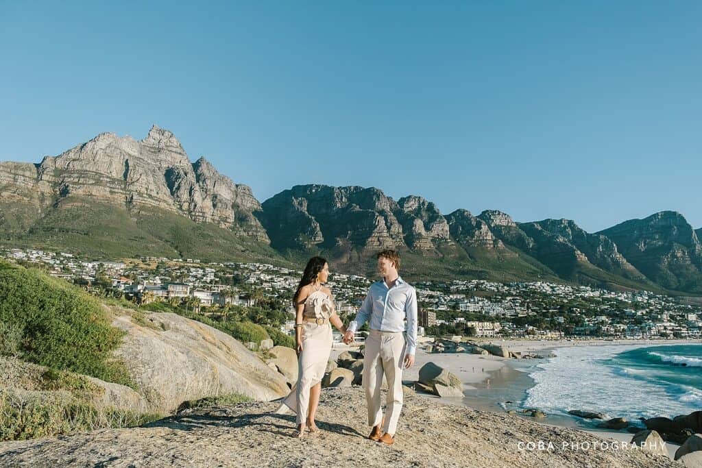 Surprise engagement at Maiden's Cove scenic lookout featuring the Atlantic Ocean and granite boulders at golden hour.